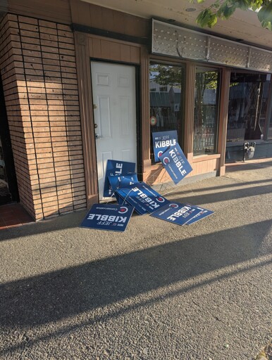A bunch of conservative campaign signs left lying on the sidewalk and door of the now closed conservative campaign headquarters in my town.